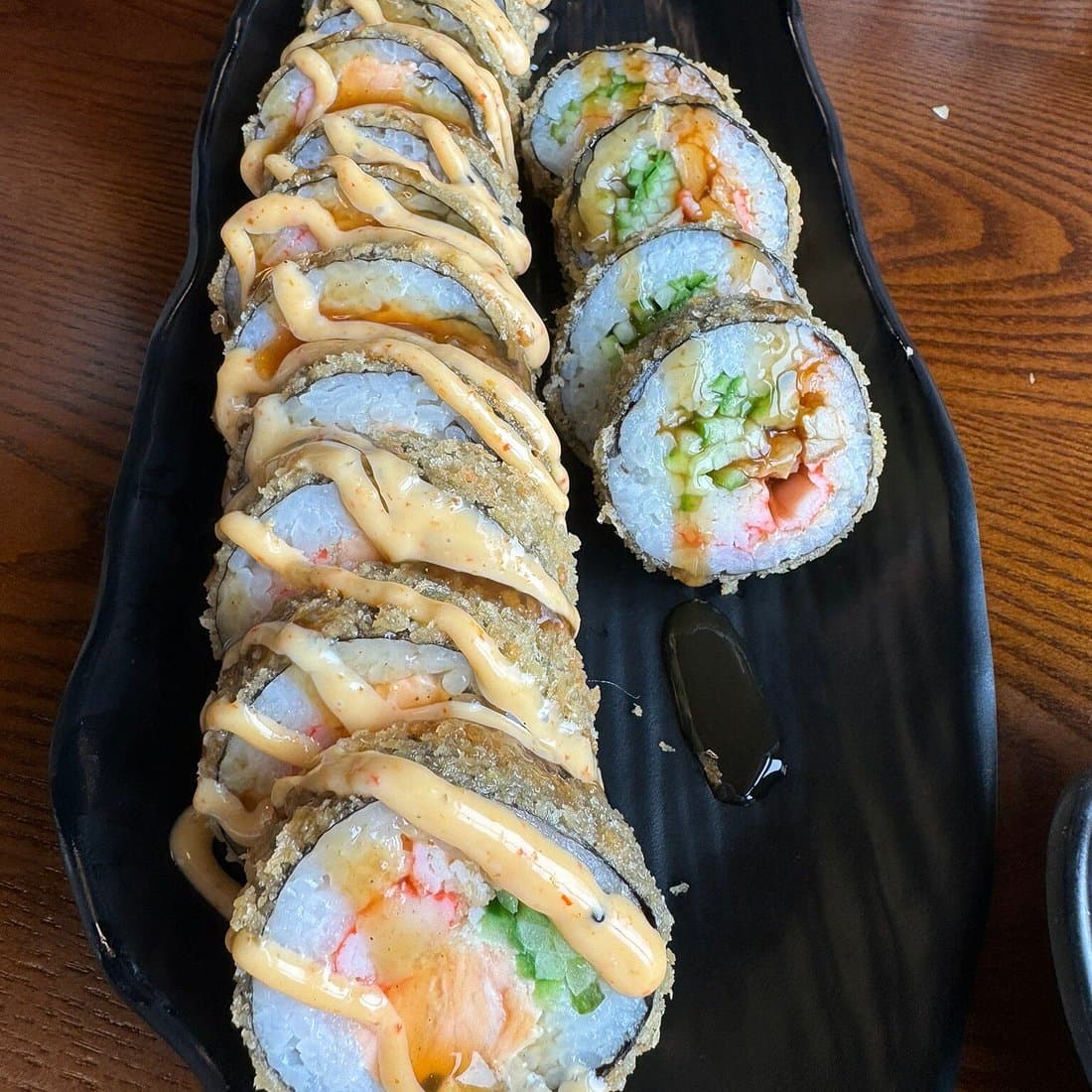 Rouleaux de sushi laqués sur table en bois